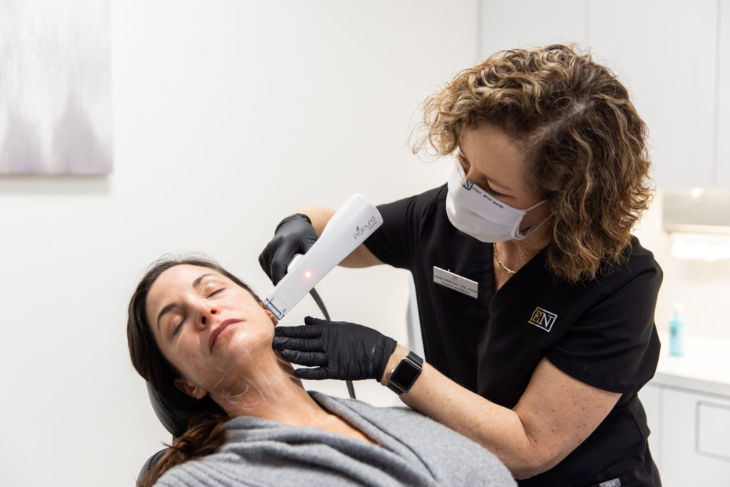 An Entre Nous provider uses the Profound device to administer a skin tightening treatment on a woman's face
