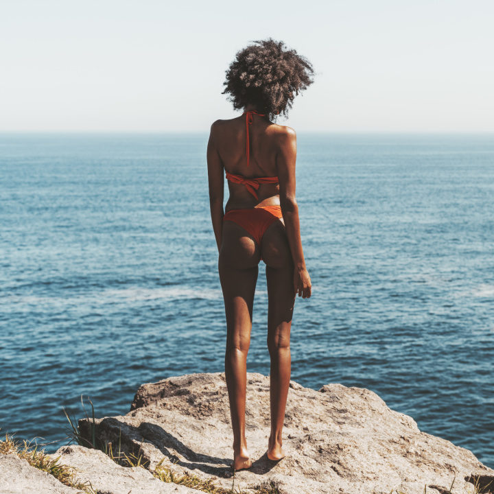 woman in bikini on a landscape facing the sea